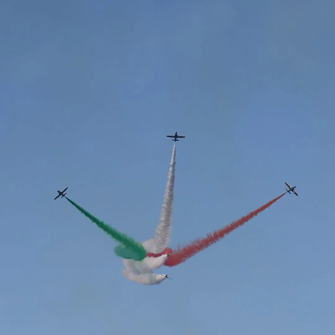 Manovra di apertura della pattuglia acrobatica con fumi tricolori.