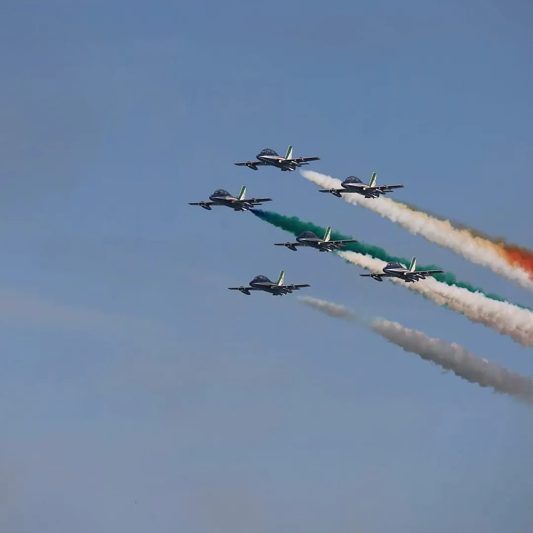 Formazione delle Frecce Tricolori con scie tricolori.