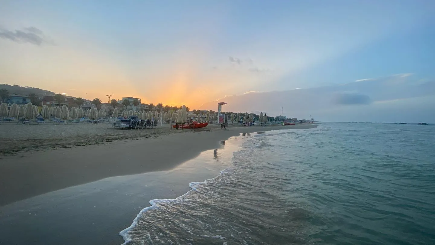 Litorale adriatico — mare calmo e passeggiata sulla spiaggia.