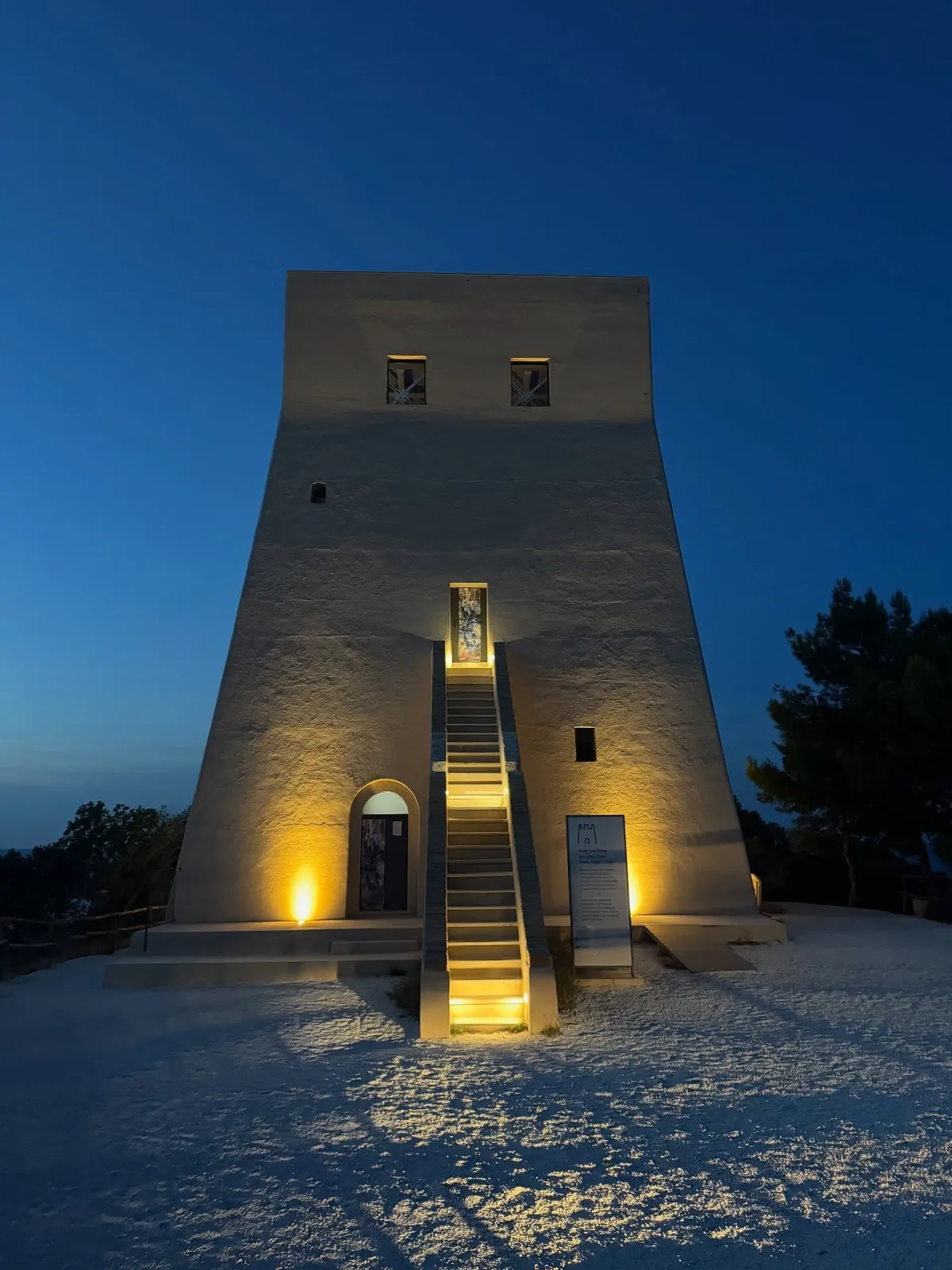 Architettura verticale illuminata nella notte, isolata contro il cielo blu.