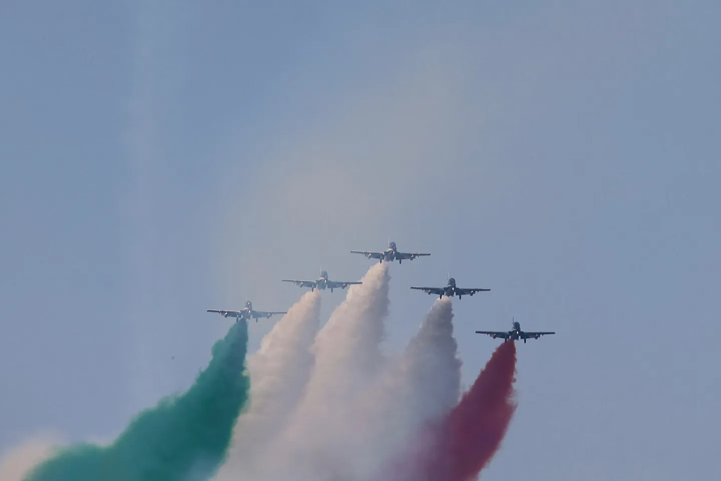 Frecce Tricolori in formazione con scie verde, bianca e rossa.