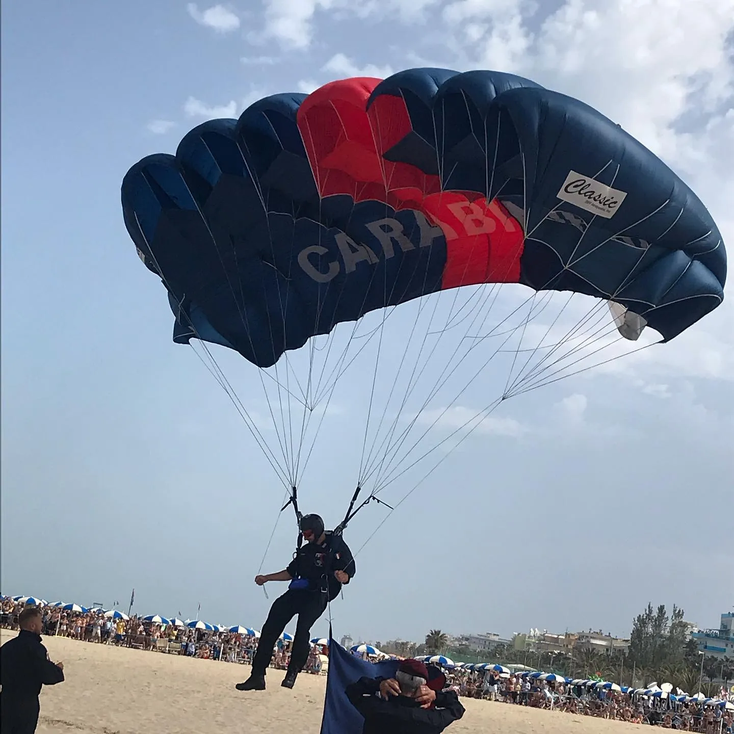 Paracadutista dei Carabinieri in fase di atterraggio durante una manifestazione.