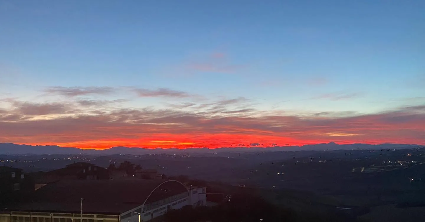 Colline e pianura al tramonto, osservate da un punto panoramico.
