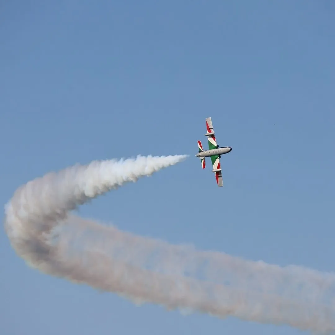 Velivolo acrobatico in virata stretta, accompagnato dalla scia di fumo.