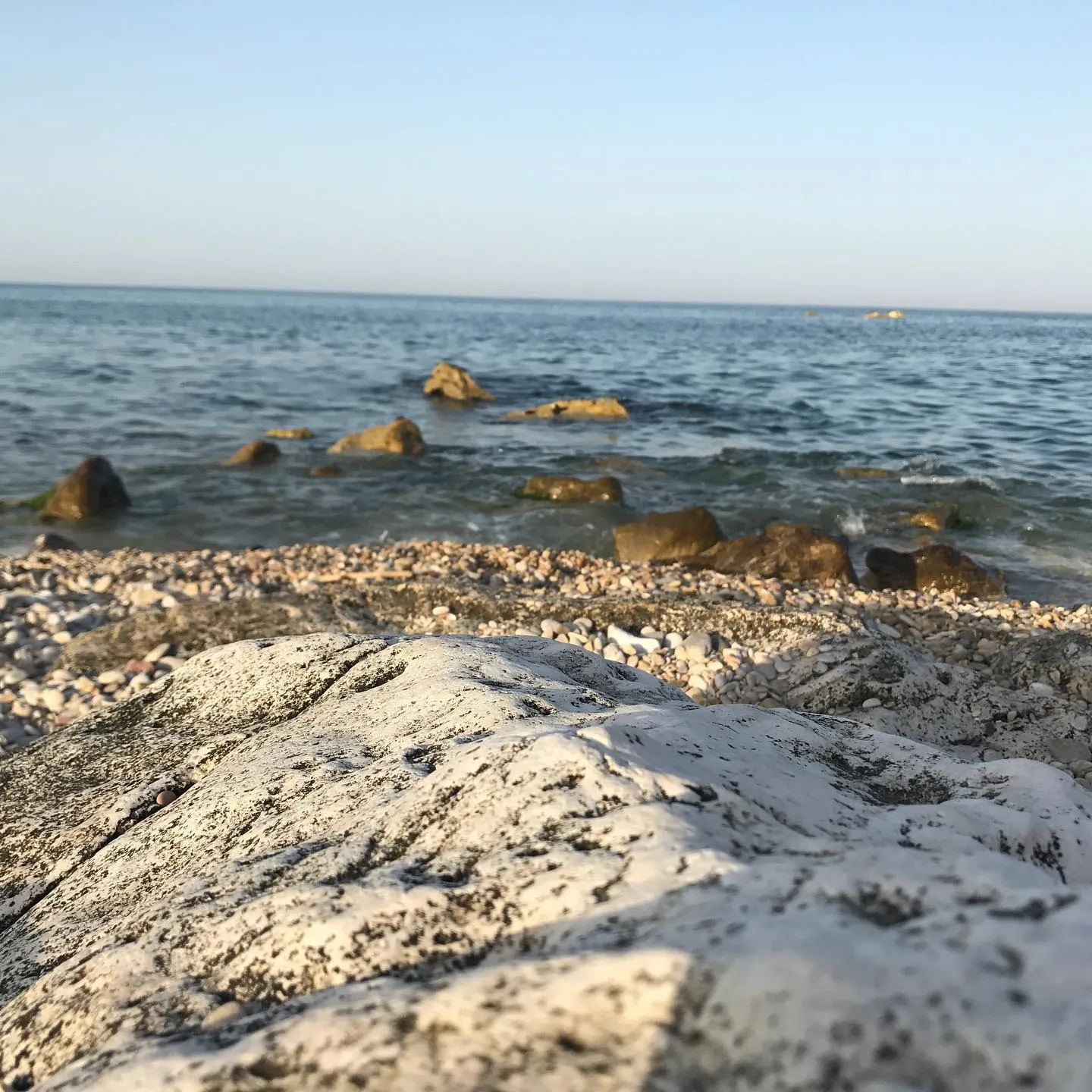 Dettaglio della costa rocciosa, tra pietra chiara e acqua.