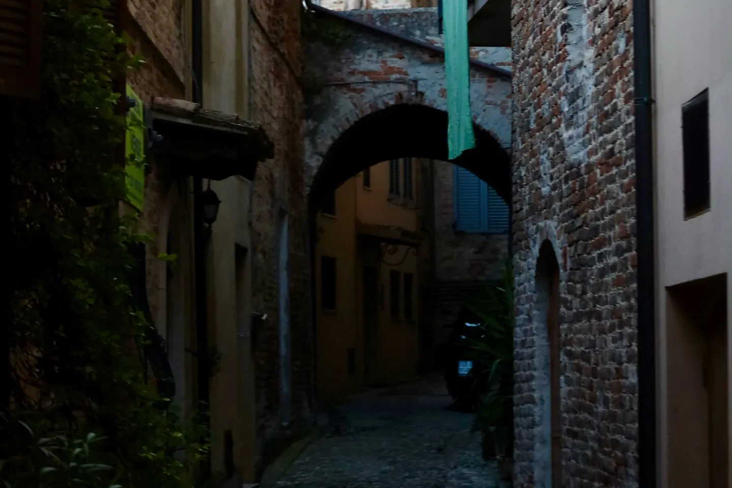 Passaggio in mattoni e vicolo raccolto in un borgo storico.