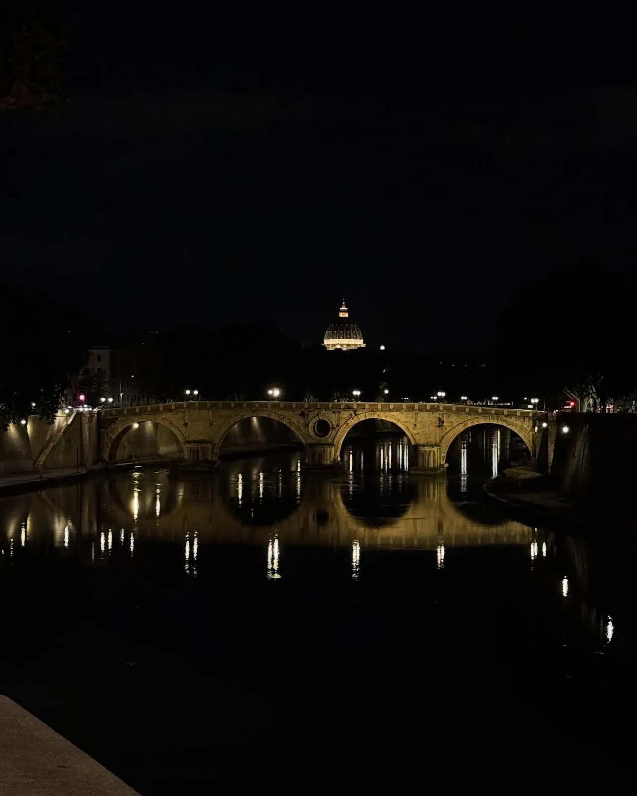 Roma — scorcio notturno sul Tevere con San Pietro sullo sfondo.