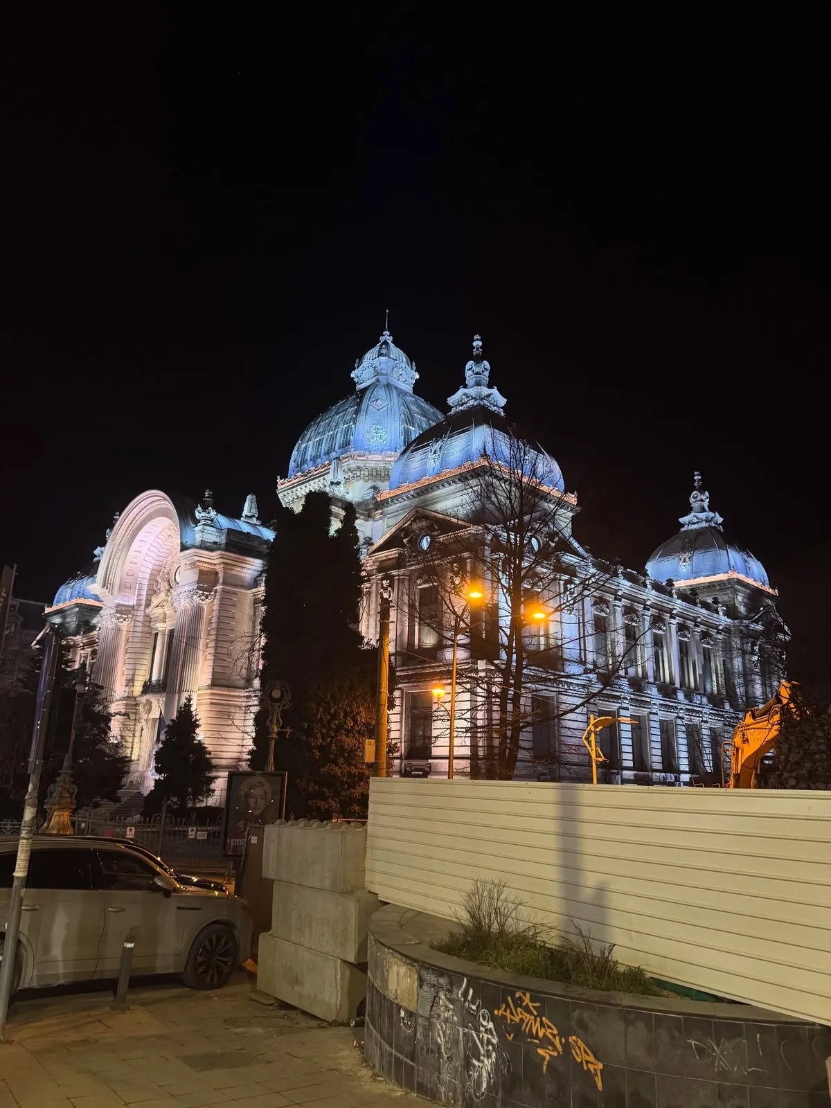 Bucarest — architettura monumentale illuminata lungo una strada del centro.