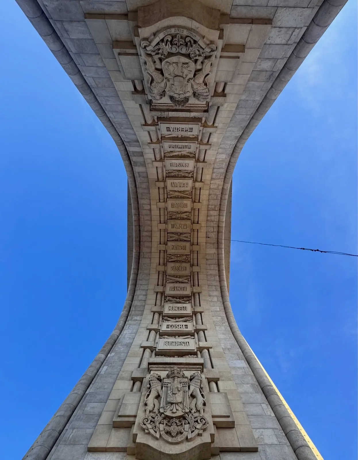 Bucarest — dettaglio architettonico dell'Arcul de Triumf visto dal basso.