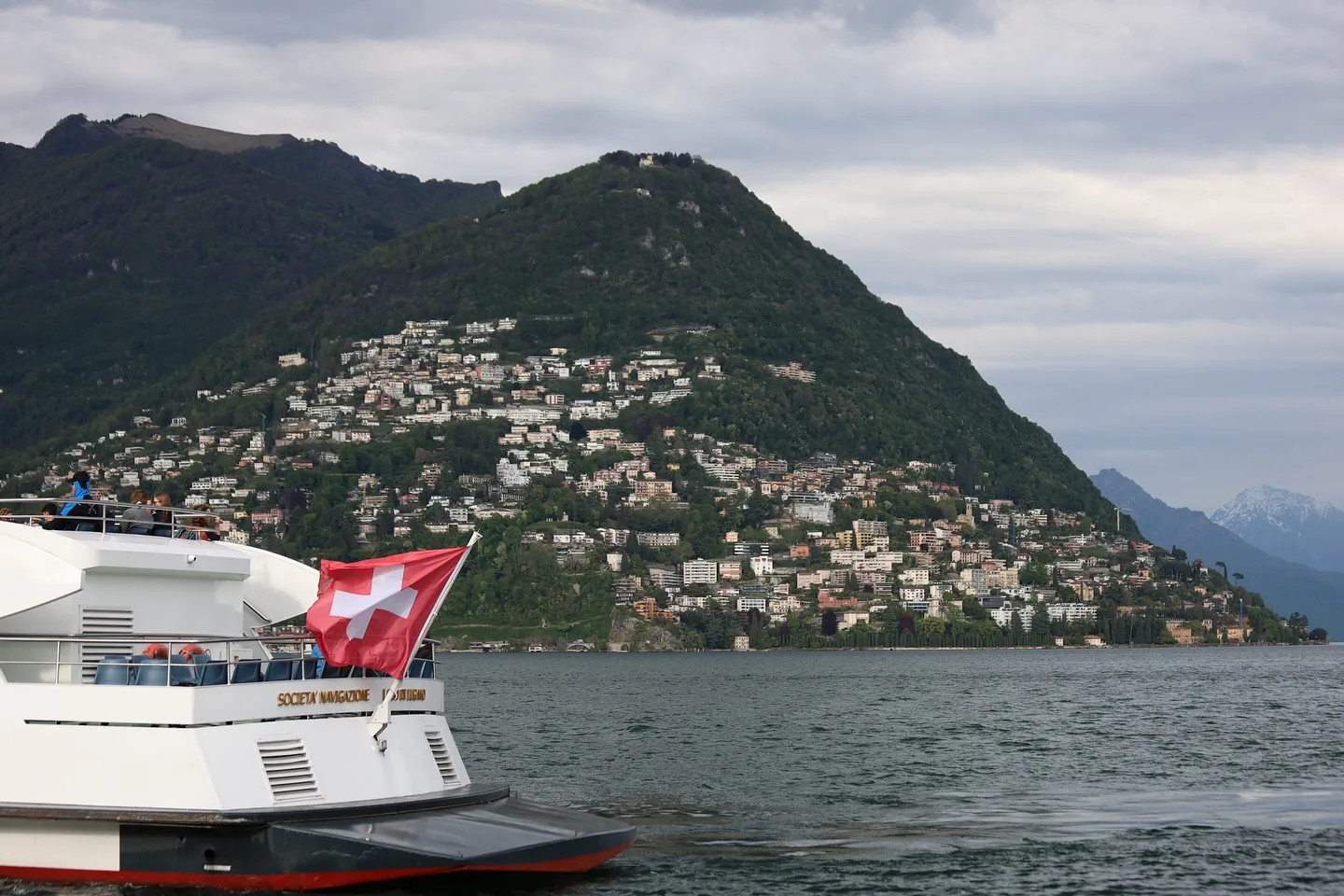 Lago di Lugano — battello svizzero e pendici costruite sulle rive.
