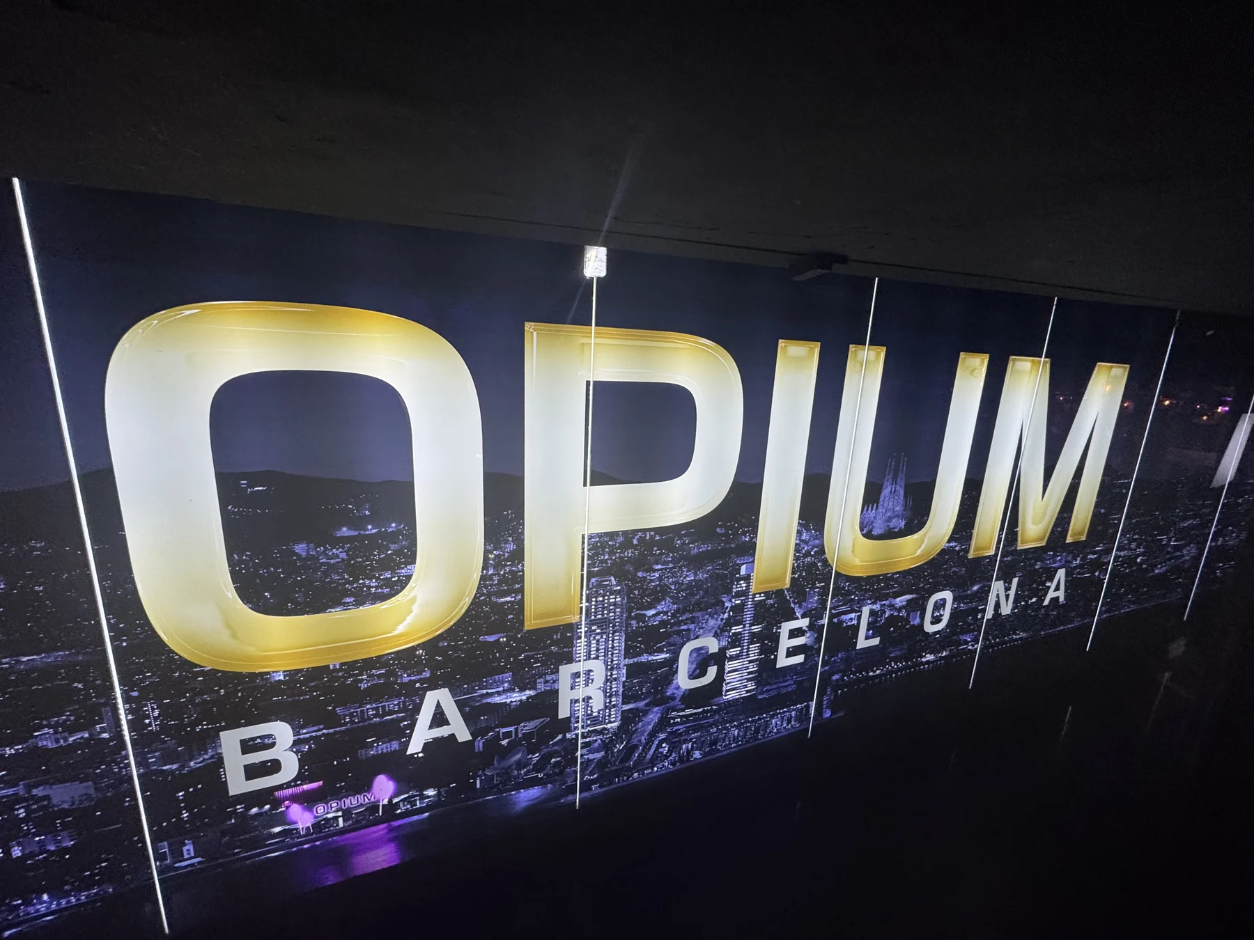 Port Olímpic — l’insegna di Opium Barcelona nella notte sul lungomare.