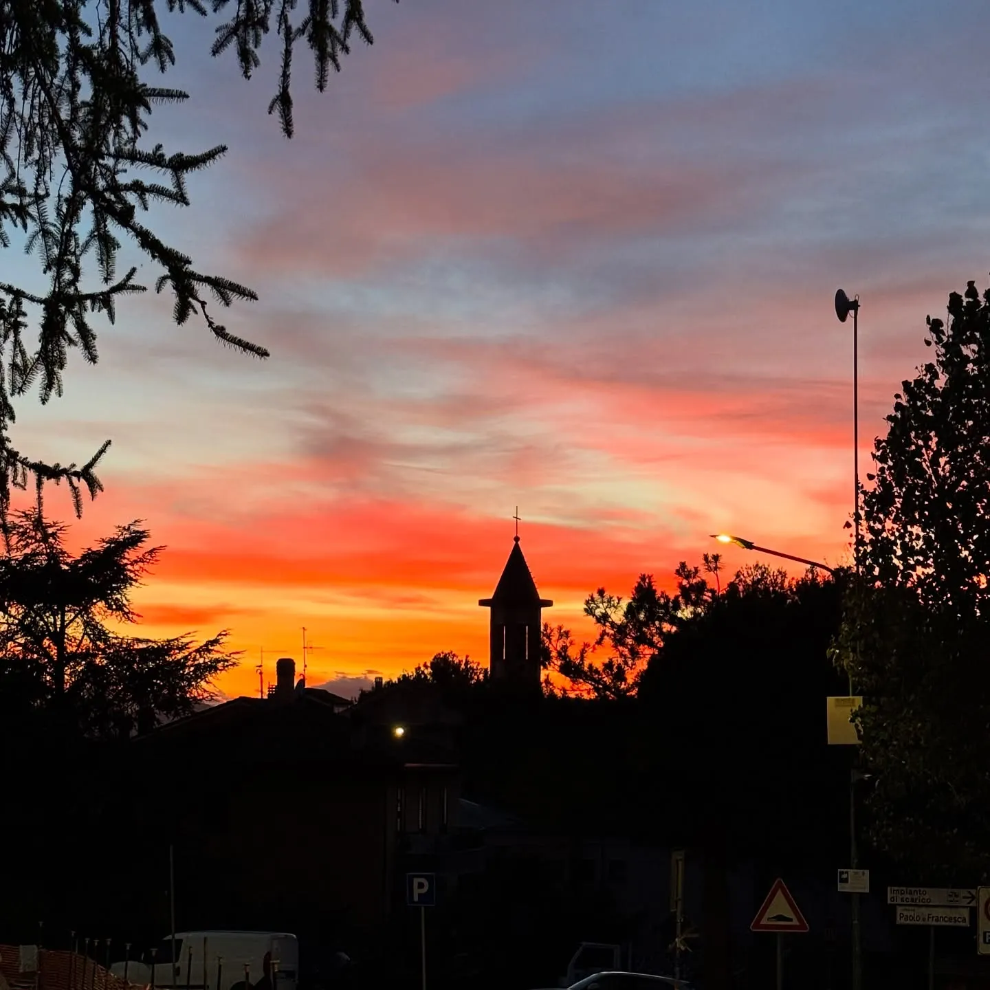 Campanile e profilo di un borgo al tramonto.