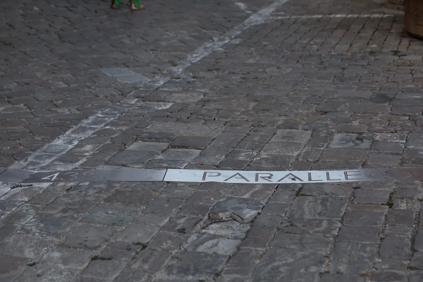 Segno urbano e pavimentazione in pietra lungo un centro storico.