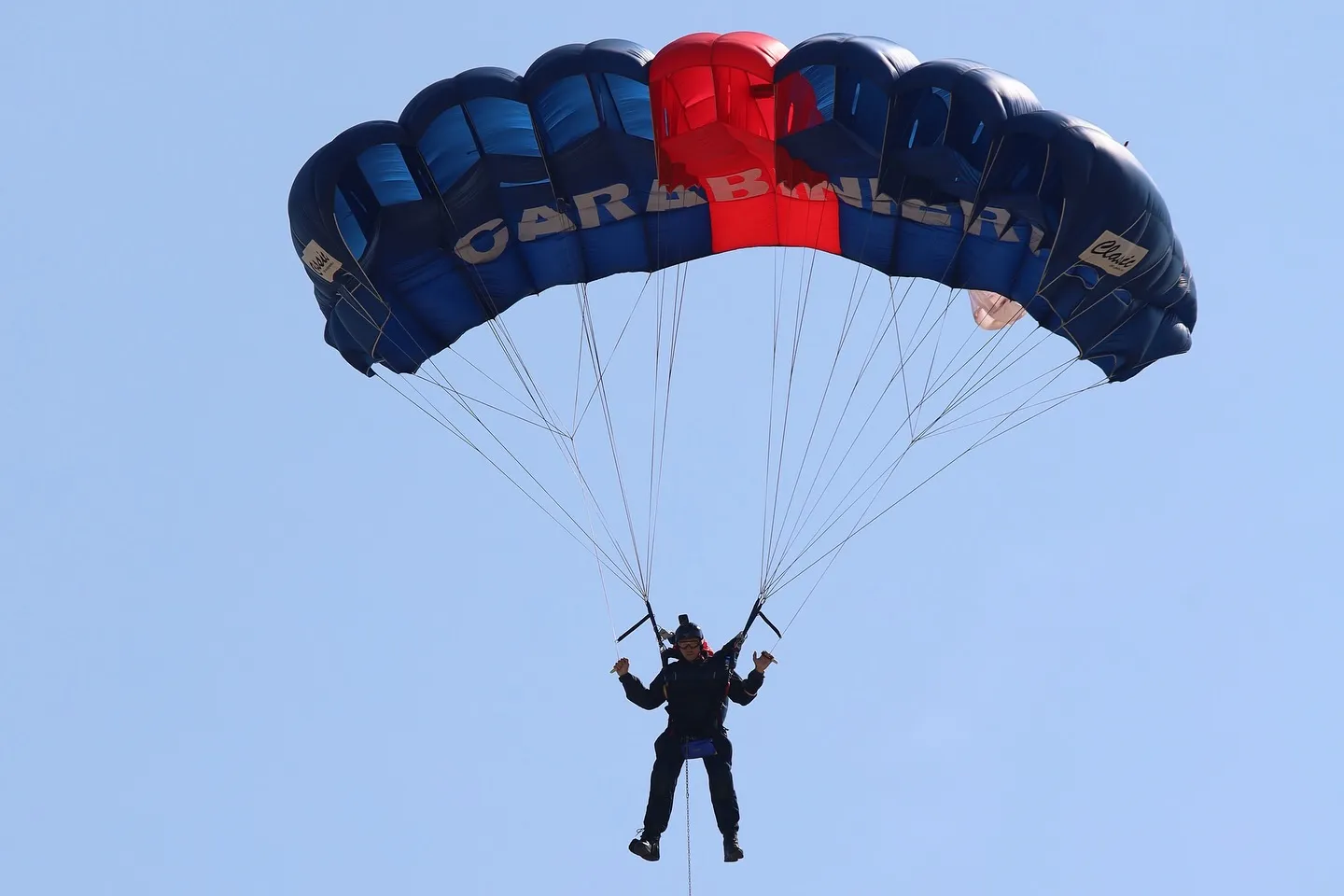 Paracadutista dei Carabinieri sospeso sotto la vela in avvicinamento.