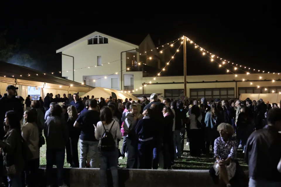 Il pubblico all'esterno, sotto i fili di lampadine.