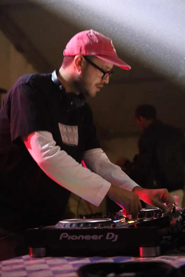 Il DJ al lavoro sulla console durante la notte del sabato.