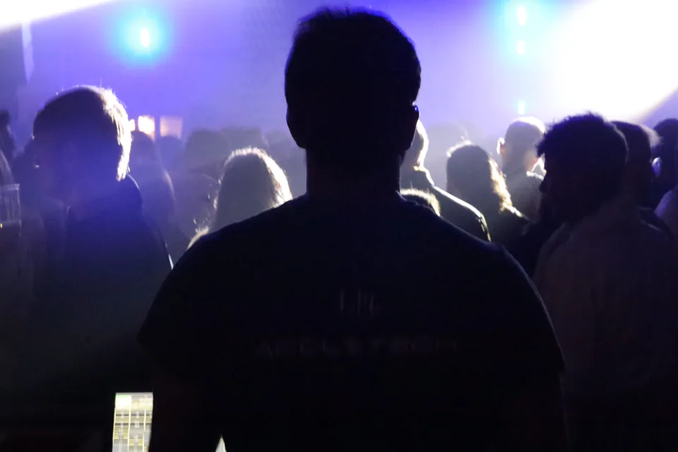 Una silhouette tra il pubblico in controluce blu.