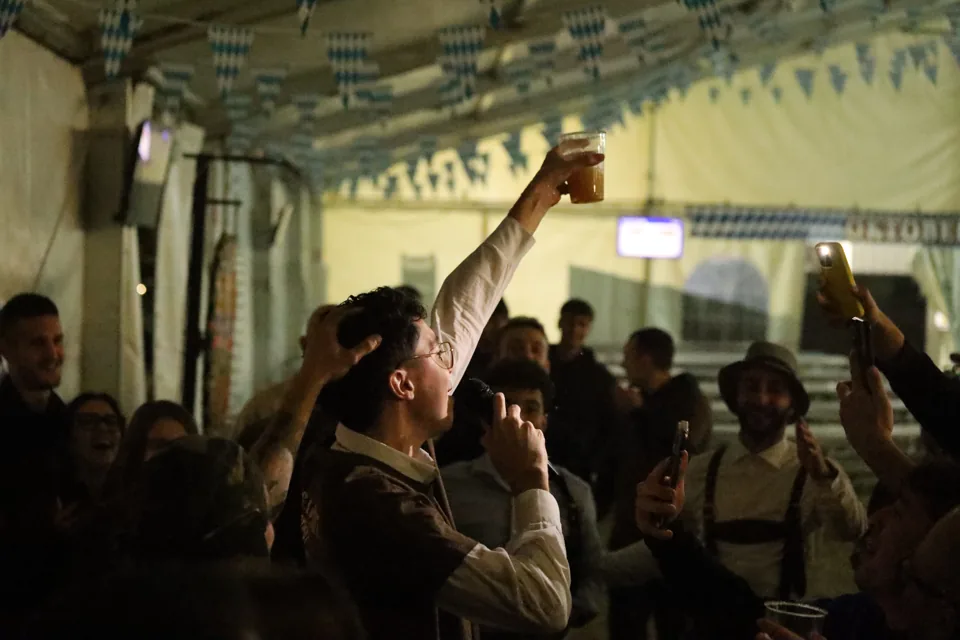 Un bicchiere alzato tra i canti della festa.